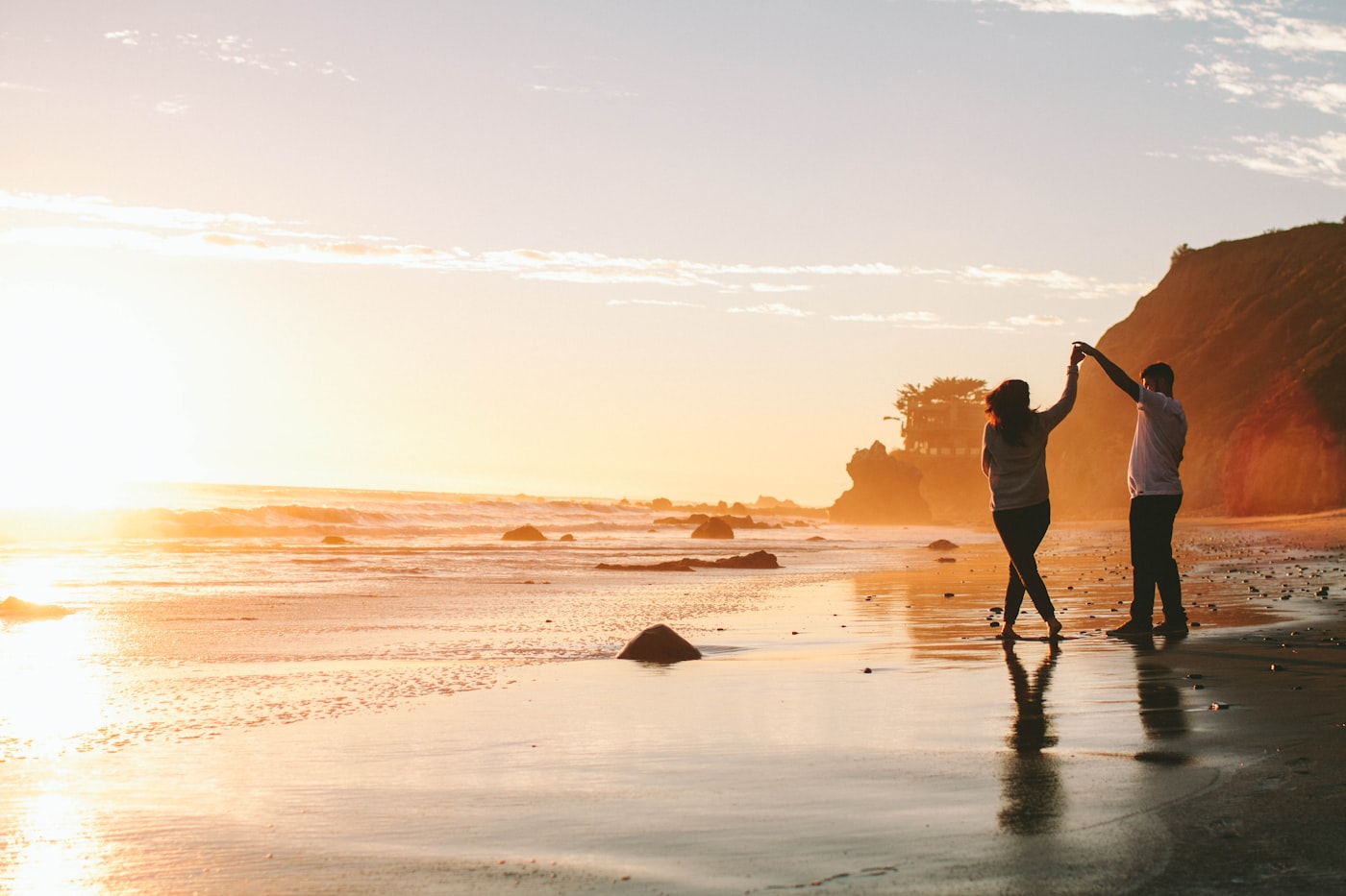 Couple walking hand in hand on a New Zealand beach