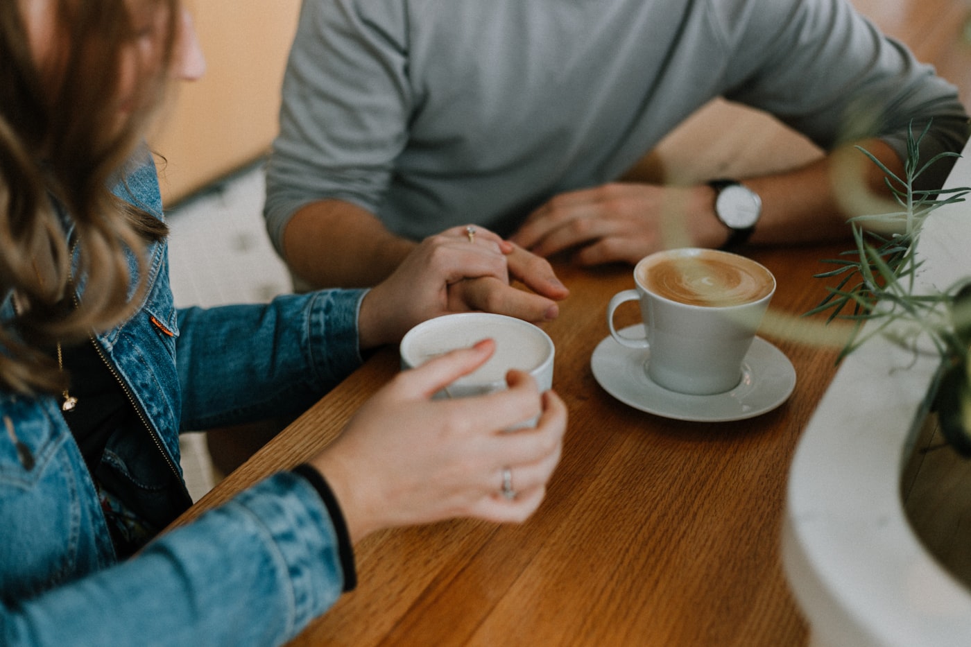 Two people laughing over coffee on a KiwiHearts date